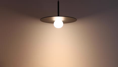 the lamps in the room are turned on and the room lights up, lamp hanging from ceiling, modern interior.