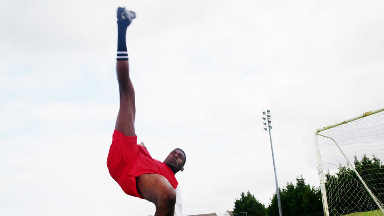 축구 선수 가 필드 에서 공 을 치고 있다