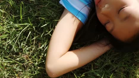 cute young girl lying on grass in park