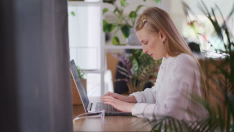 mujer alegre escribiendo en una computadora portátil