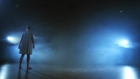 Slow-motion:-female-dancer-on-stage-in-smoke.-Modern-ballet-barefoot-on-stage.