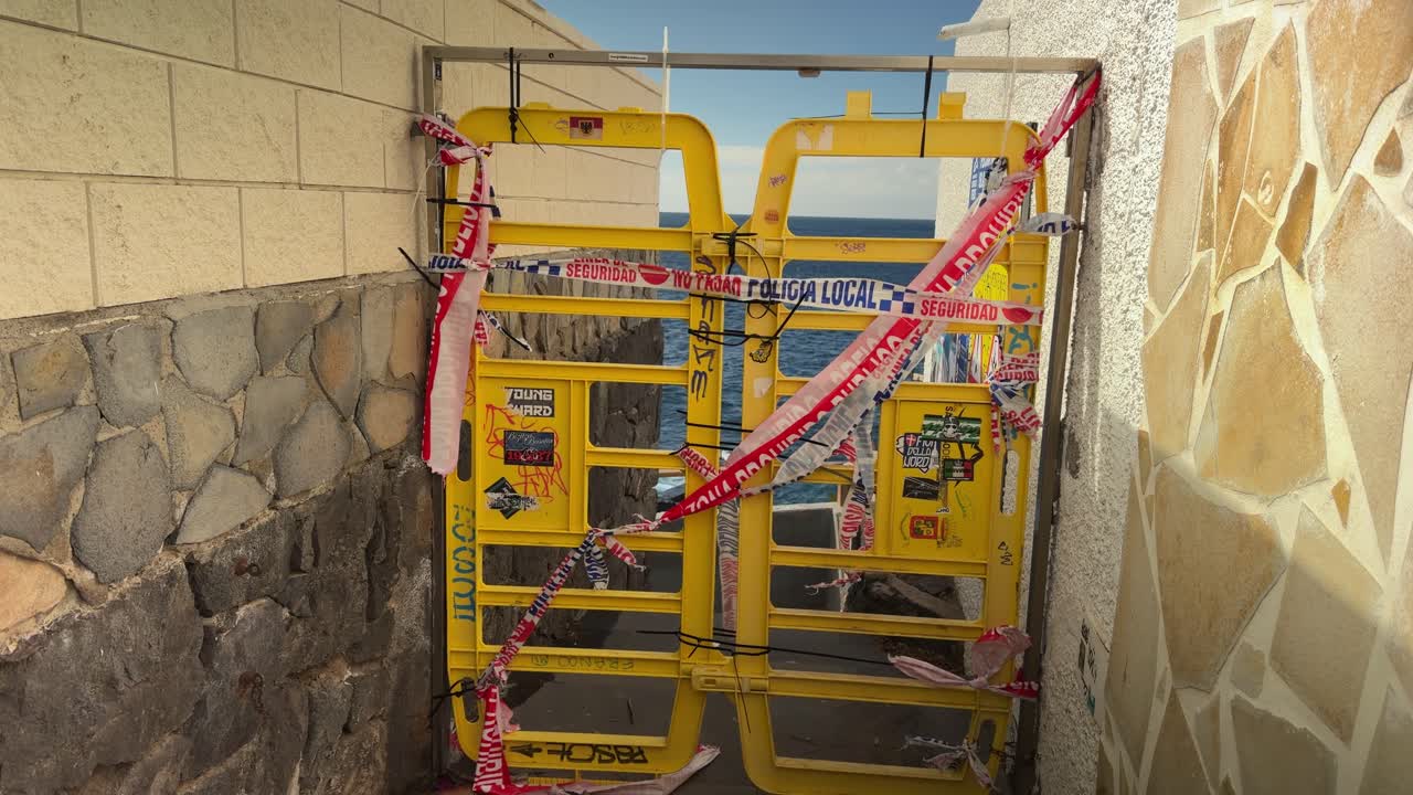Puerta cerrada en Puerto Santiago con telón de fondo de mar agitado.