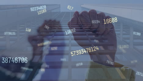 animation of numbers processing over fists and modern office building
