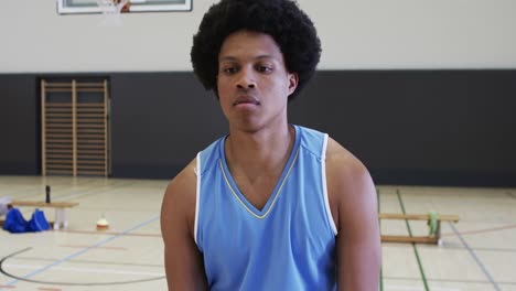 Portrait-of-african-american-male-basketball-player-playing-in-indoor-court,-in-slow-motion