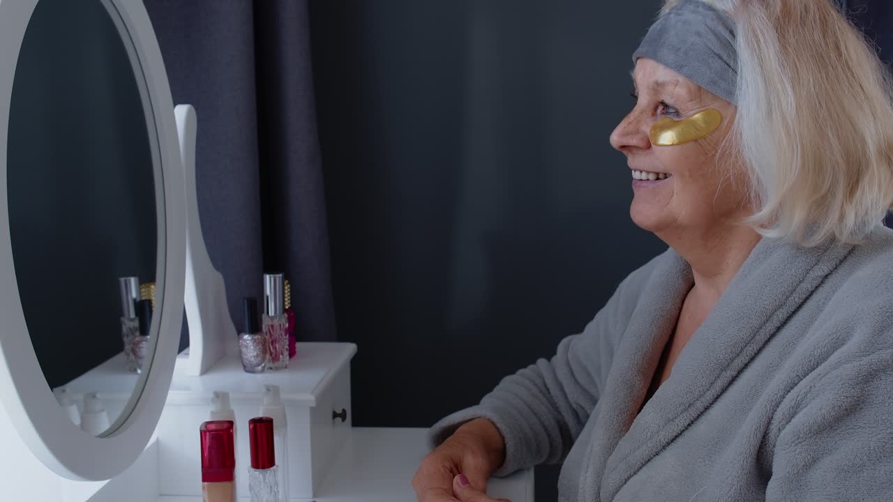 Donna anziana che applica patch per gli occhi in bagno