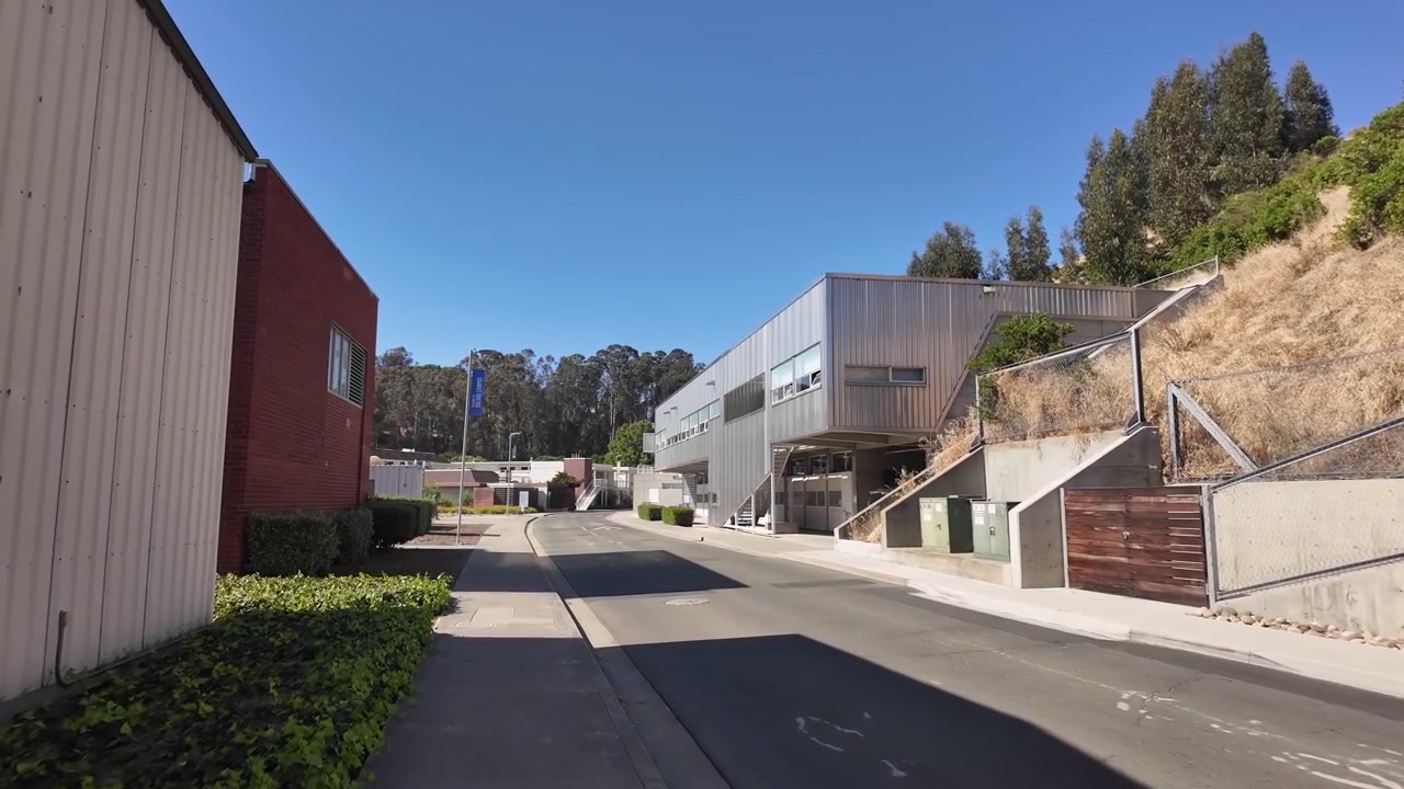 Vista em progressão da Academia Marítima da Universidade Estadual da Califórnia, também conhecida como Academia Marítima Cal Poly, campus localizado em Vallejo, mostrando arquitetura moderna e céus ensolarados