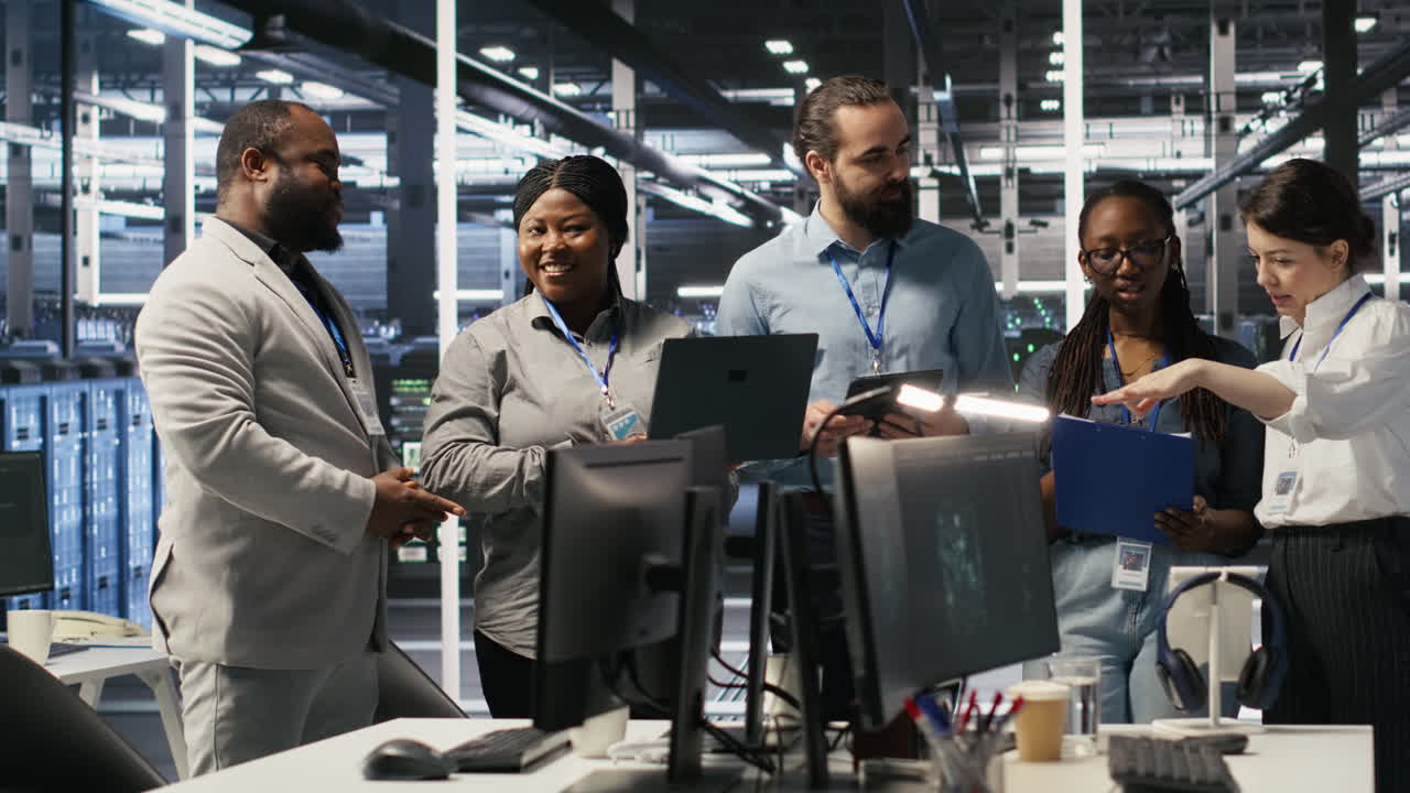 Vertical video Smiling engineering team in server room reviewing infrastructure diagnostics
