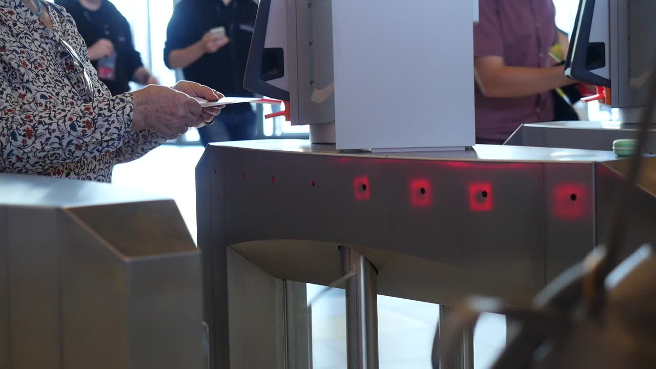 보안 게이트에서 티켓을 스캔하는 사람