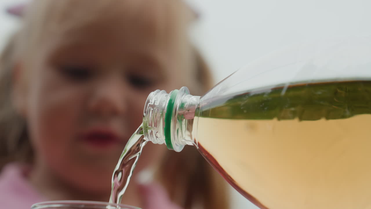 흰색 머리 소녀가 호박색 액체가 쏟아지는 것을 지켜보고 있어요. 젊은 과학자 역할극, 뒷마당 실험, 집중된 시선, 초록색 병목에서 액체가 쏟아져 나오고 있고, 아래에는 유리잔이 기다리고 있어요. 얼굴을 감싸는 땋은 머리, 부드러운 흐린 날씨의 빛