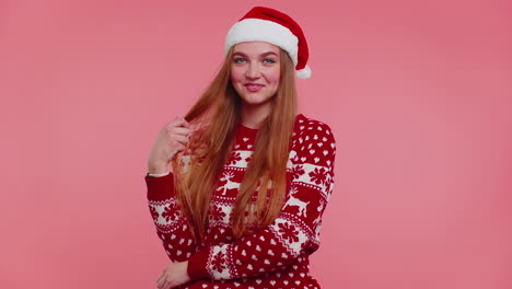 alegre chica encantadora lleva suéter de navidad rojo y sombrero sonriendo mirando a la cámara, feliz año nuevo