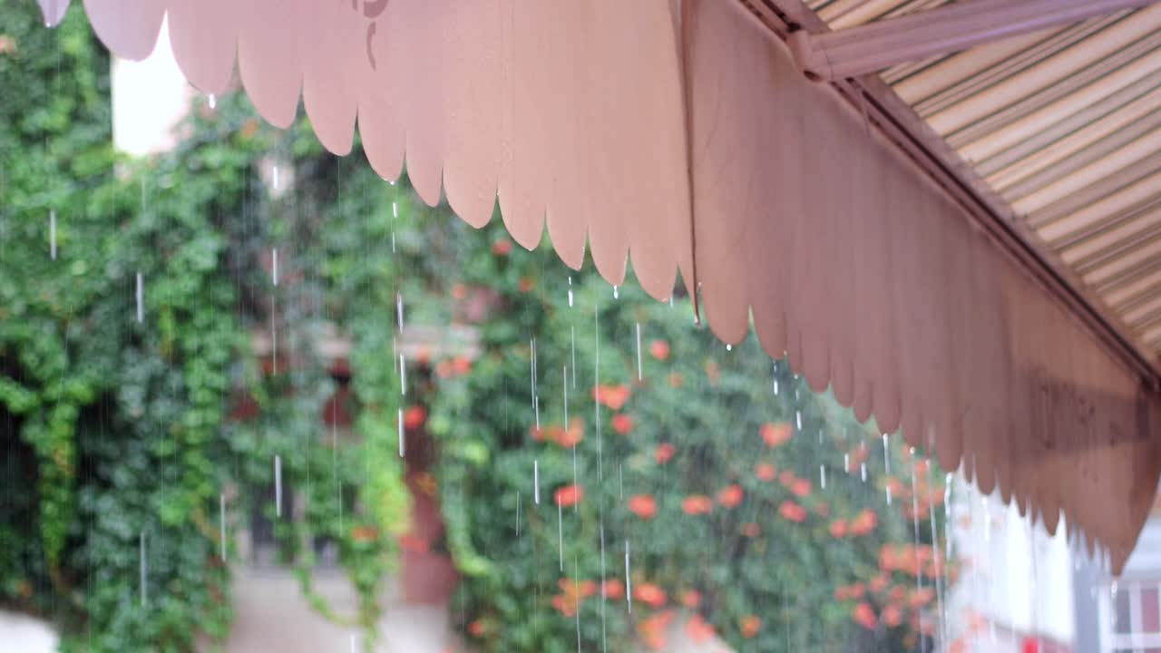 카페 의 천막 에 비 가 내리고 있다