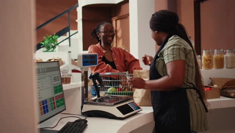 retailer placing goods on electronic scale at cash register