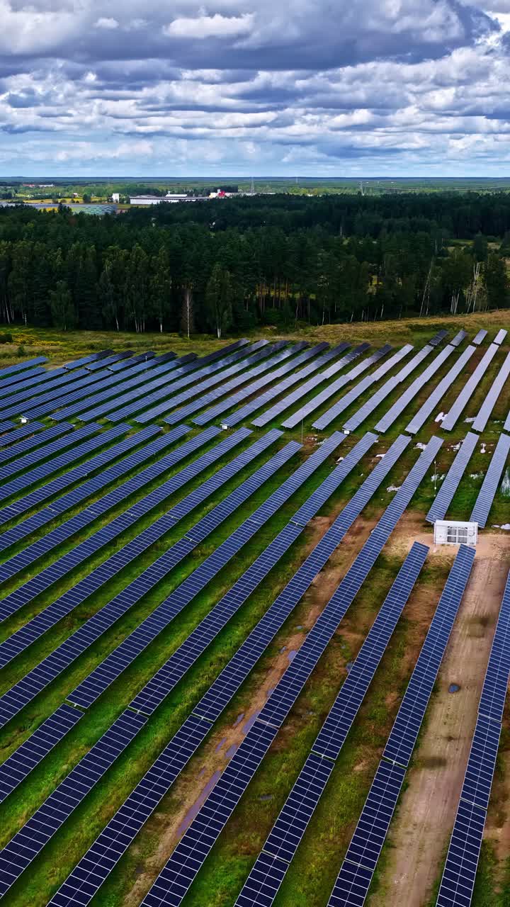 Panoramic aerial view of a huge solar panel park next to forests