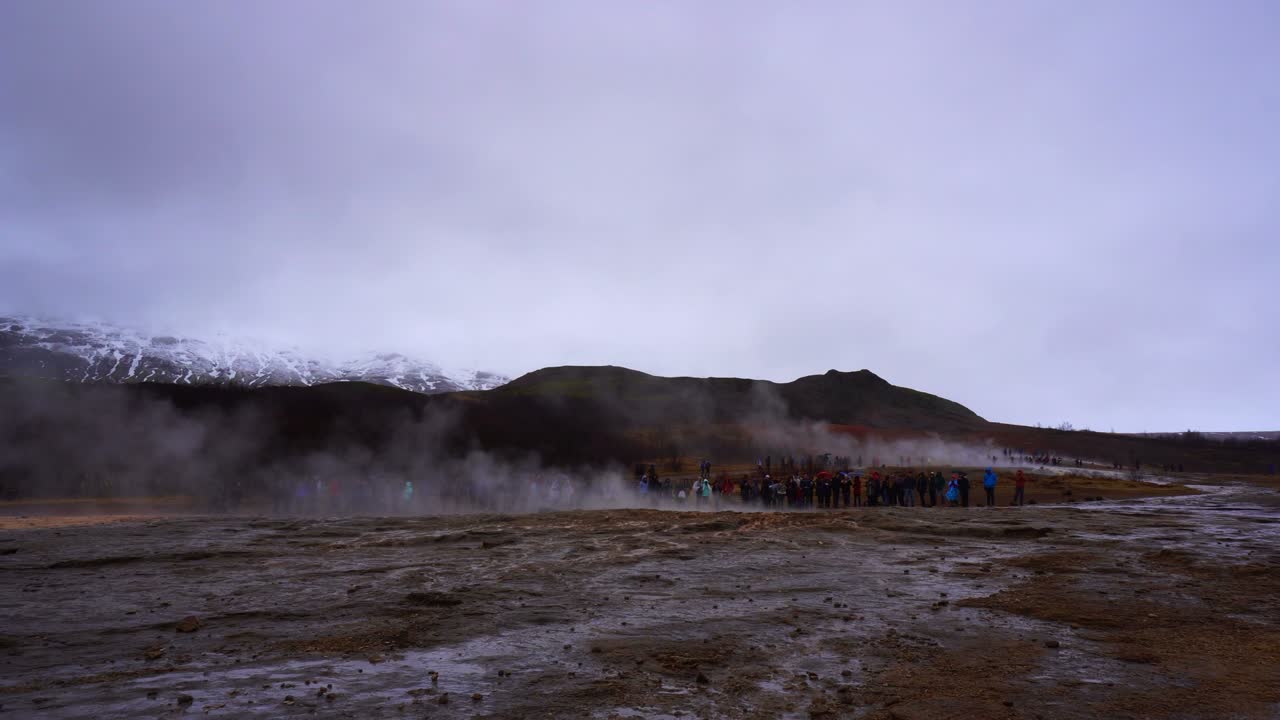 la gente espera que el geyser explote en islandia.
