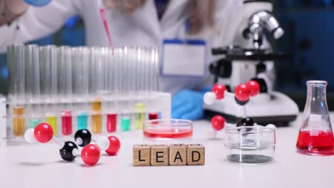 scientist conducting an experiment in a laboratory with various scientific instruments and the word "lead" spelled out