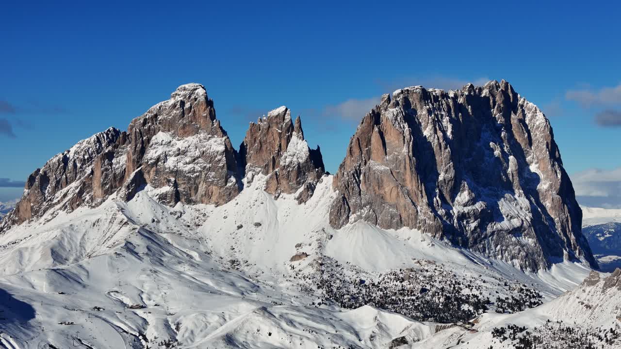 Huge rock formation in Italian Dolomites covered with snow during winter season (drone footage)