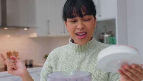 Woman-tasting-healthy-smoothie-in-blender