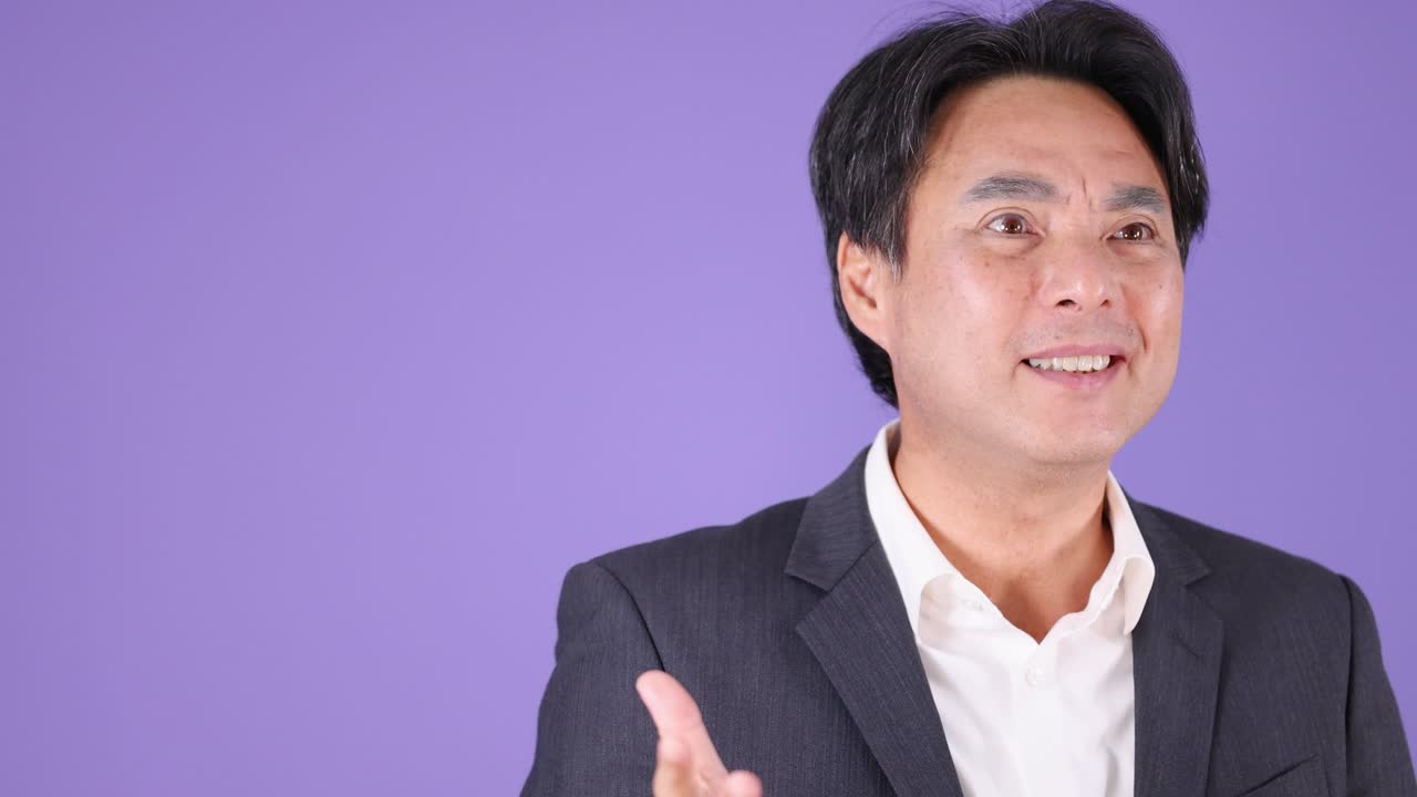 Businessman in suit displays anger, surprise, and relief against purple studio background, steady camera