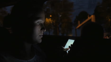 Mujer-Con-Celular-En-El-Auto-Por-La-Noche