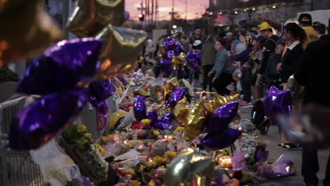 lakers balloons fly in wind as fans pay tribute at kobe bryant memorial, nighttime