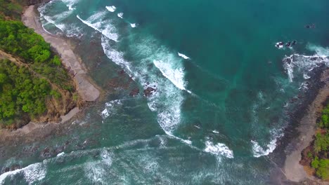 Volando-Hacia-Una-Brecha-En-La-Tierra-De-Playa-Herradura-En-Costa-Rica-Para-Revelar-El-Hermoso-Y-Accidentado-Terreno-A-Lo-Largo-De-La-Costa.