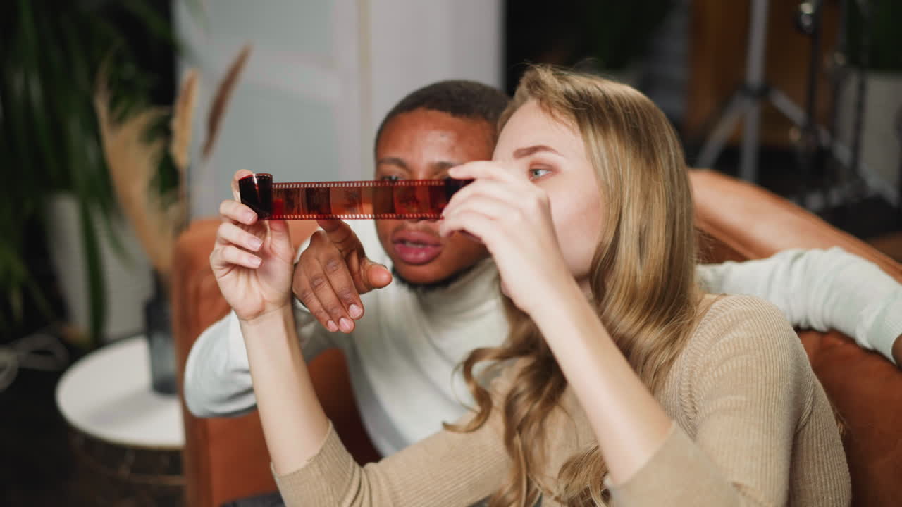 una mujer blanca con un colega negro elige fotos para imprimir