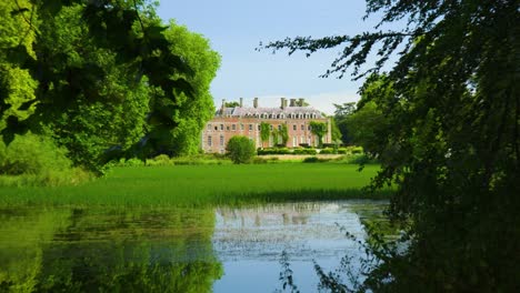 mansion-big-posh-house-in-the-middle-of-nowhere-across-a-lake-overgrown-with-nature-dark-places-zooming-out-from-the-property-thriller-horror-cinematic-pull-creative-cinematic-scene-clear-sky