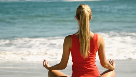 woman meditating on the beach