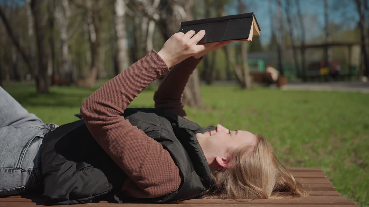 donne si rilassano e leggono sotto un cielo terso, donne si distendono all'aria aperta immergendosi nella lettura, donne si godono il tempo libero all'aperto leggendo libri sotto il caldo sole e il cielo blu
