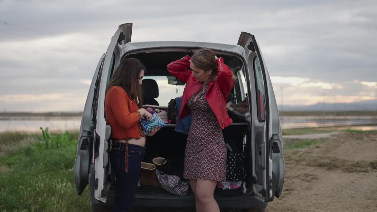 Two women preparing for a trip in a van