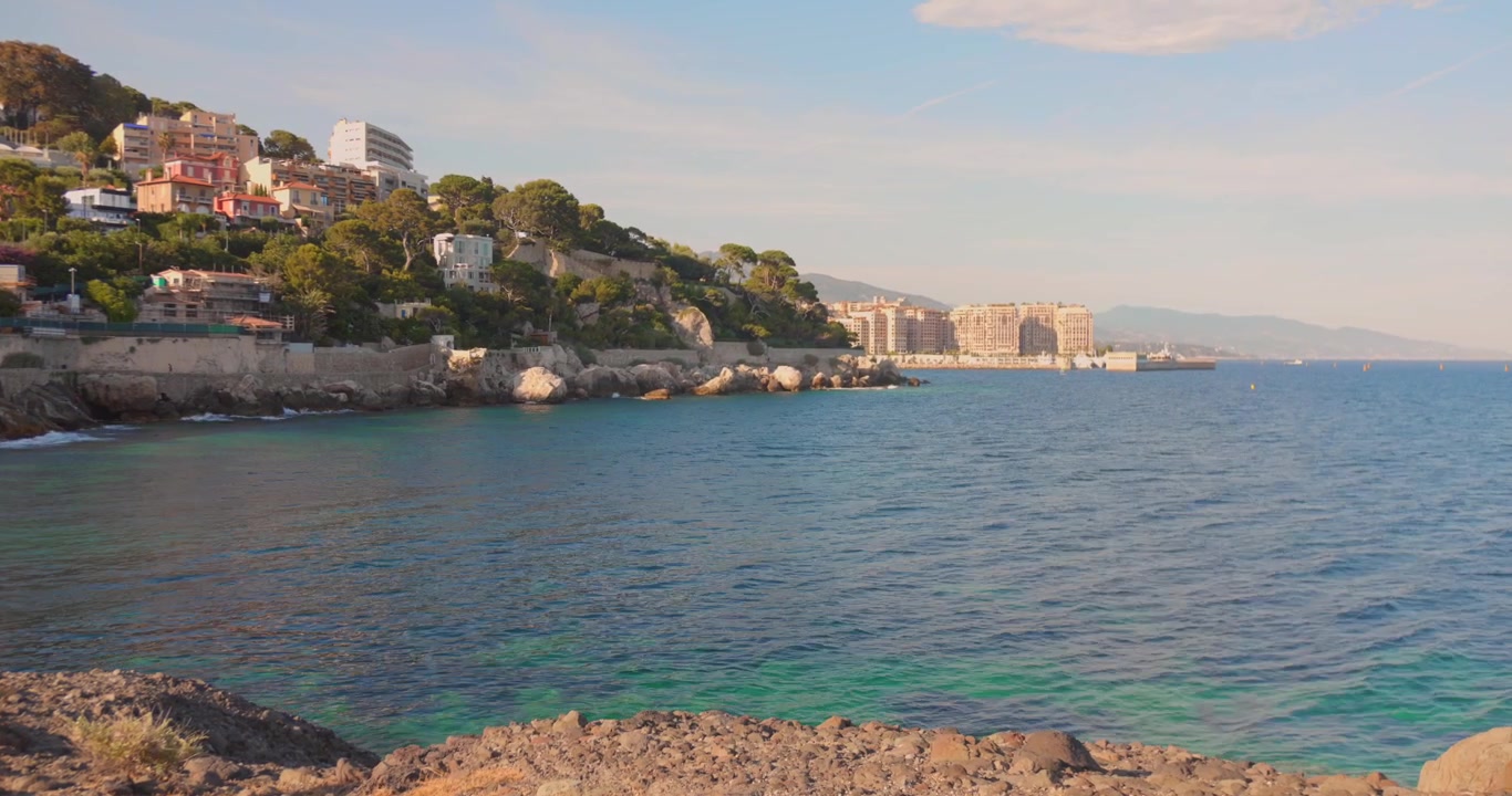 Panoramica costa mediterranea dal famoso sentiero costiero di Cap d'Ail, con acqua cristallina e case in collina vicino a Monaco.
