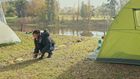 Set-up,-camping-and-woman-by-lake-with-tent