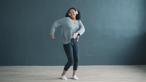 woman dancing to music with headphones