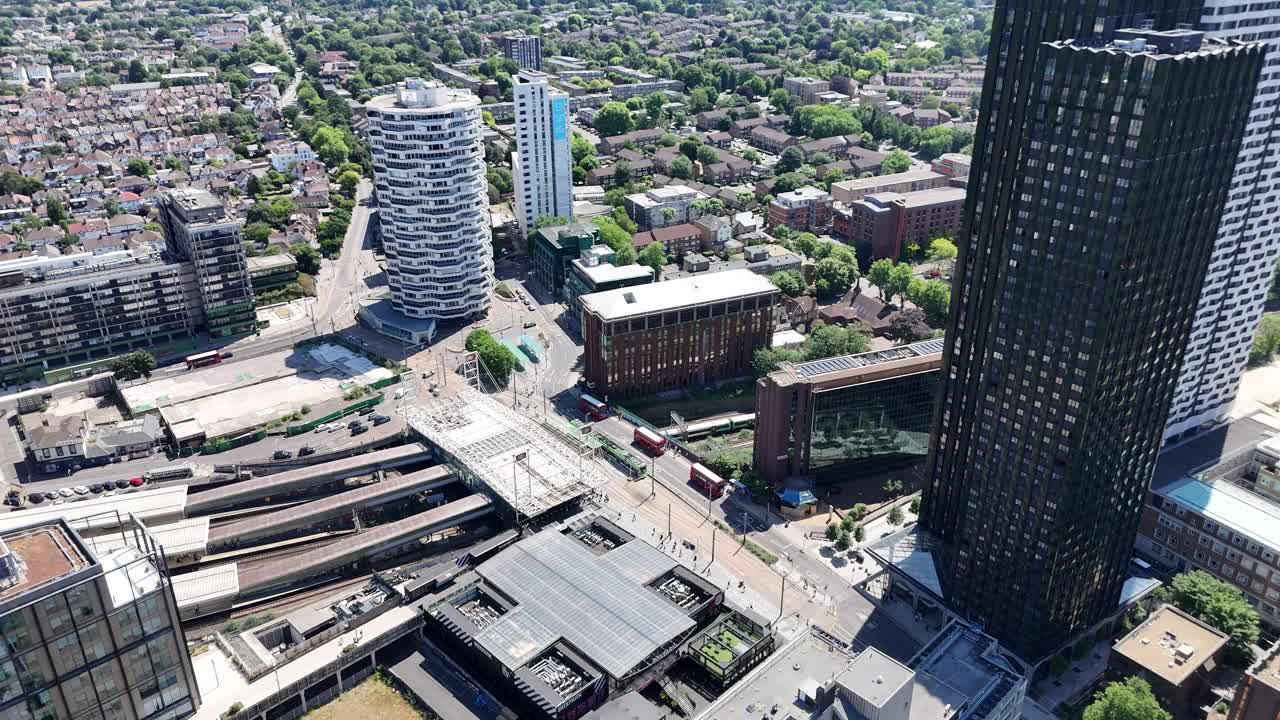 Dynamic aerial view of East Croydon Station in London. Trains, buses, taxis, and trams converge in this vibrant transport hub, capturing the energy of a bustling urban interchange.