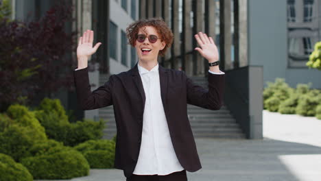 businessman smiling friendly at camera waving hands gesturing hi greeting or goodbye welcoming