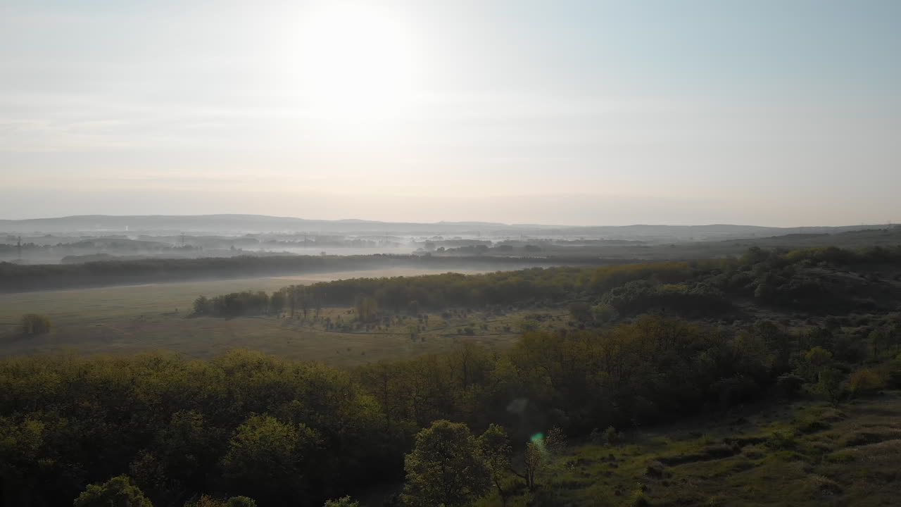 자연 경관과 함께 안개 낀 들판의 전망을 확립하는 공중 풀백, 아침