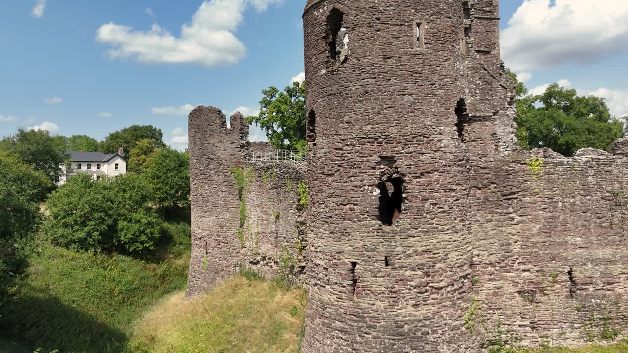 Detailed close approaching drone footage of the walls and tower at the majestic ruins of Grosmont Castle with views over the Welsh Border on sunny summer day