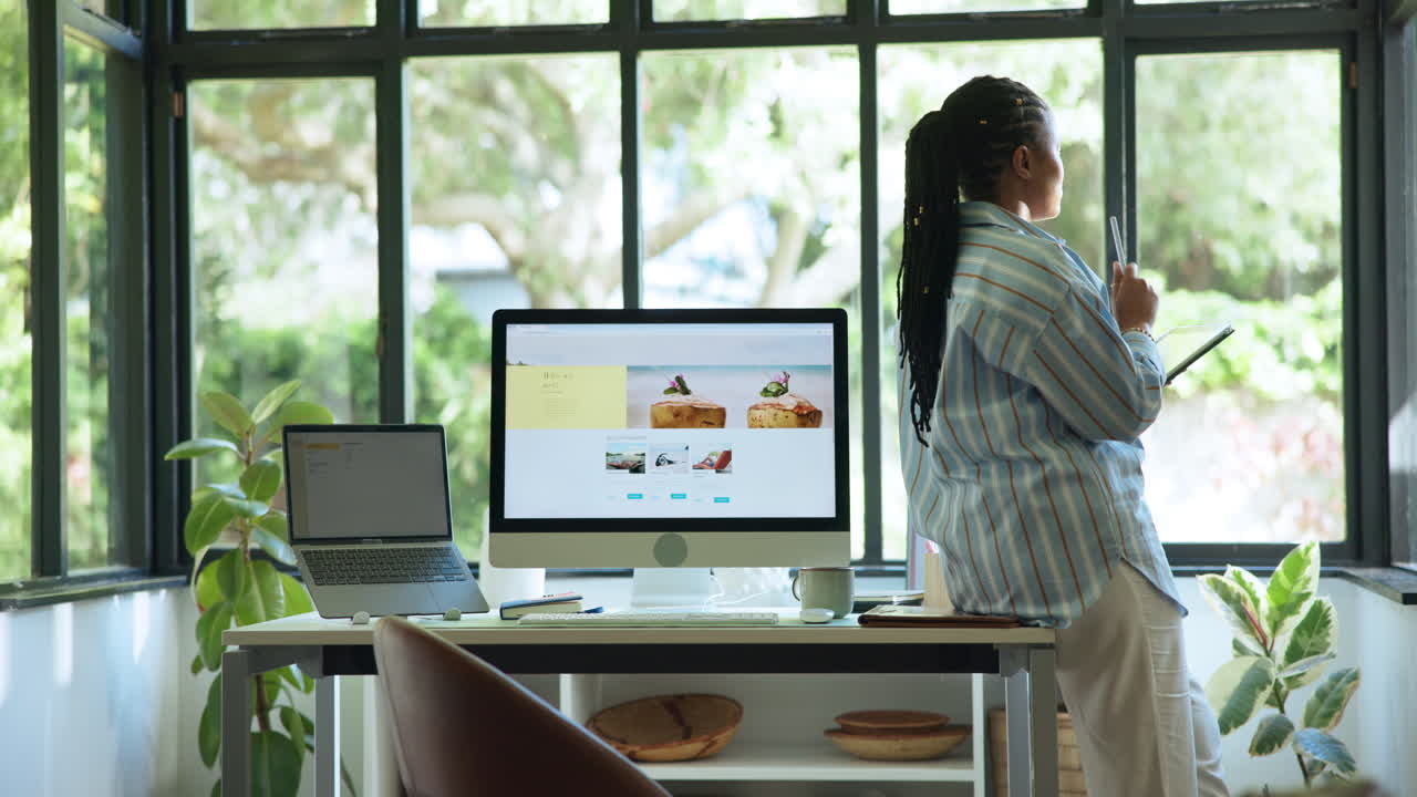 Woman Standing at Desk with Tablet and Laptop in Home Office