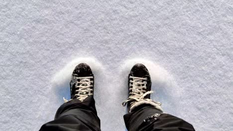 top down view person ice skating outdoors on fluffy snow - pov shot