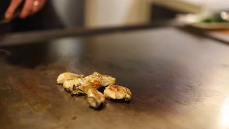 oysters sizzling on a hot teppanyaki grill