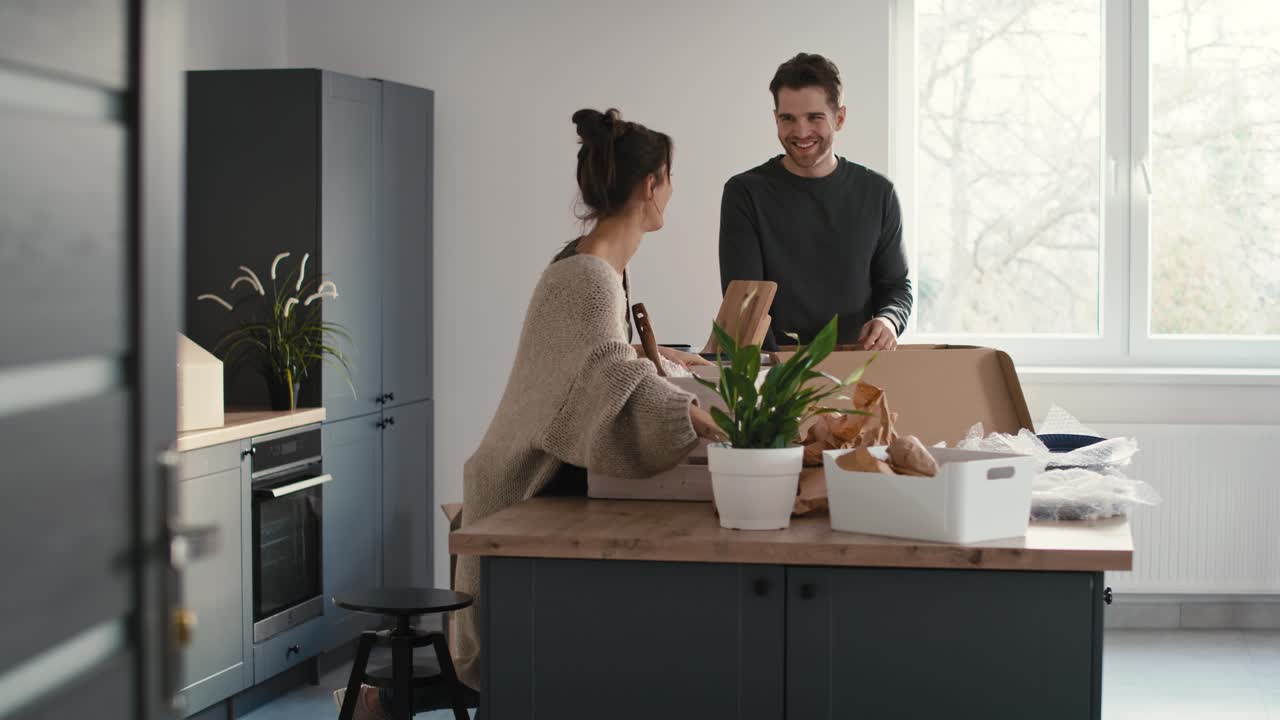 Caucasian couple packing some kitchen stuff and chatting