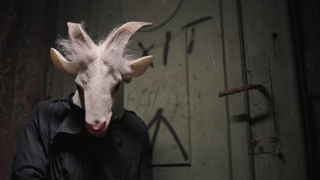 person with goat mask in an abandoned building