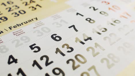 man's hand lays out red paper heart on the 14 february month in a calendar. love holiday for young and old