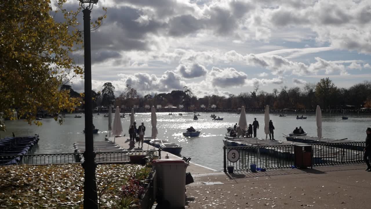 People enjoying a sunny day at a park lake