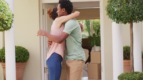 happy biracial couple holding keys to new house and embracing with joy