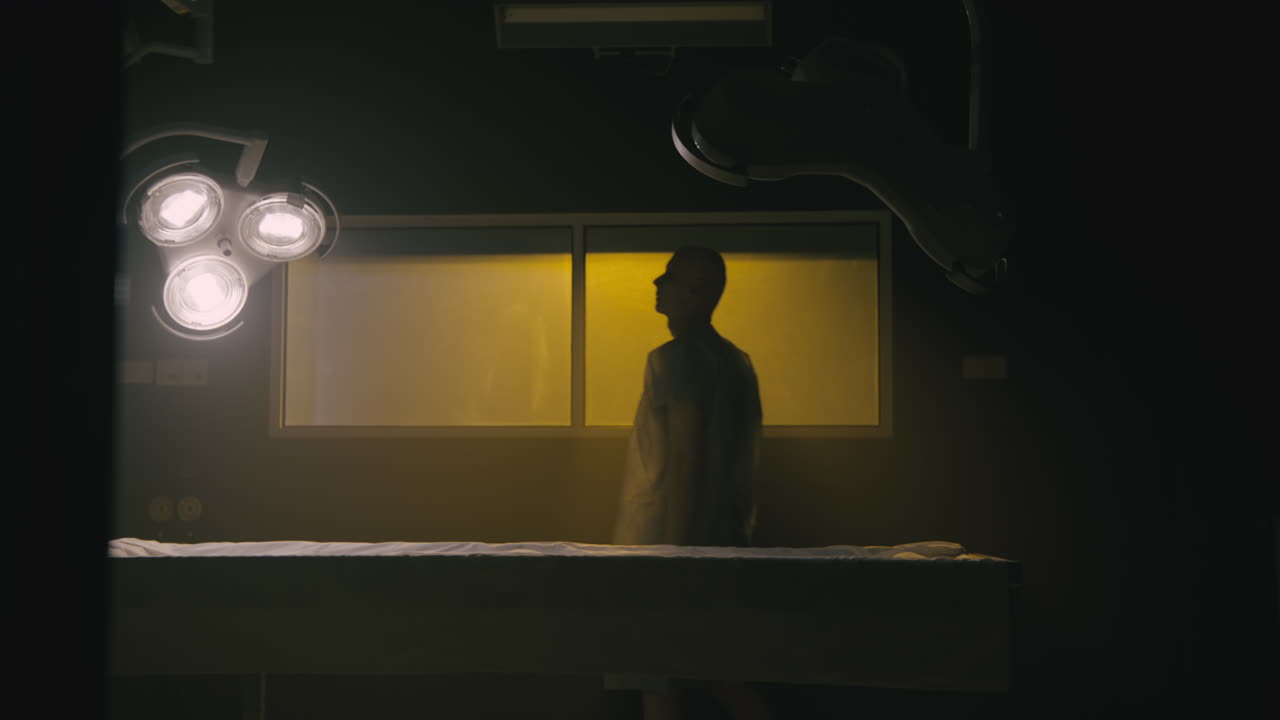 A bald man wakes up in the empty operation room