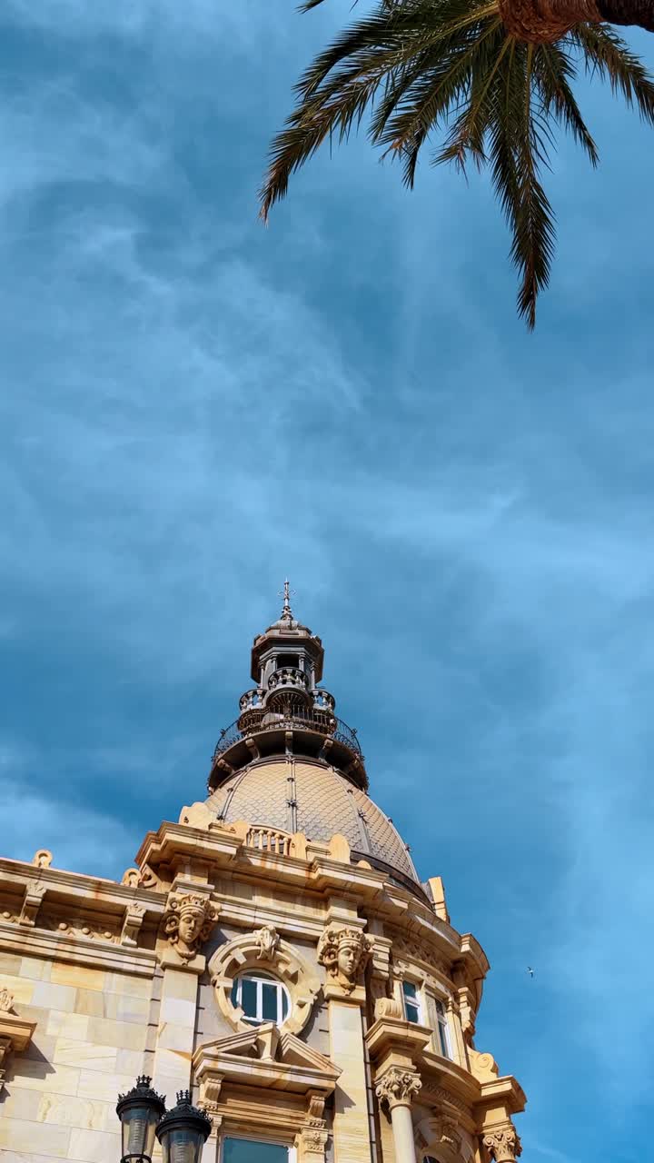 Cupola ornata e dettagli architettonici di un edificio storico spagnolo. Vista ravvicinata di una cupola decorativa e sculture in pietra sul Palacio Consistorial a Cartagena, Spagna