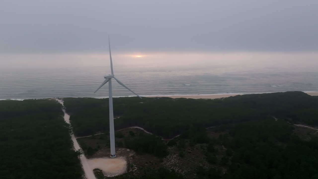 해안 풍력 터빈과 해가 지는 모습