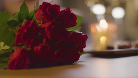 close up of roses with wine and chocolates for romantic valentines day at home