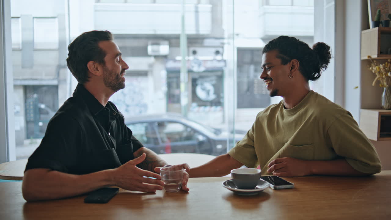 Couple gays relaxed meeting in restaurant close up. Two guys talking smiling